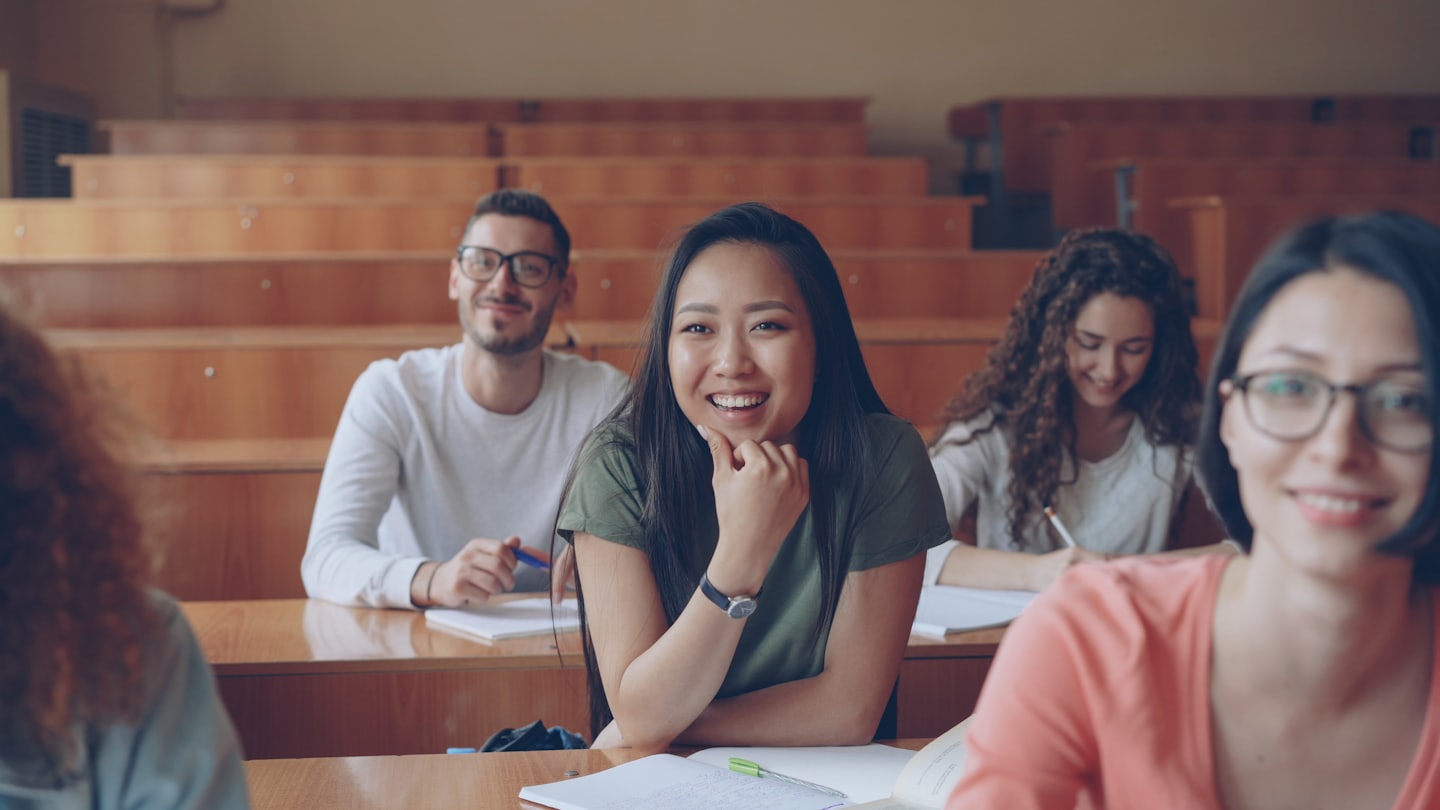 University students in a lecture hall listening attentively.